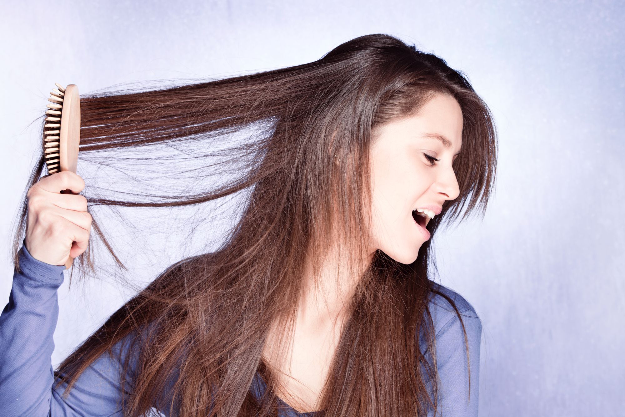 kobieta rozczesuje naelektryzowane włosy
